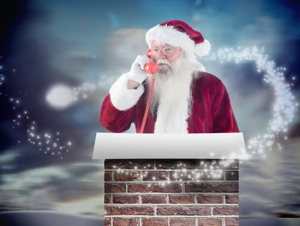 Samengestelde afbeelding van santa op zijn rode telefoon — Stockfoto