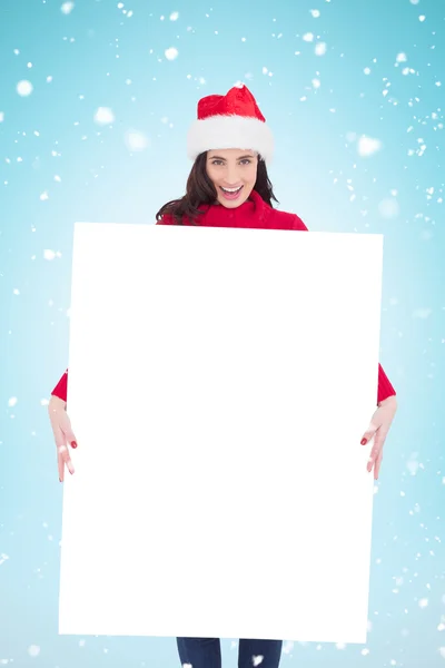 Brunette in santa hat showing poster — Stock Photo, Image