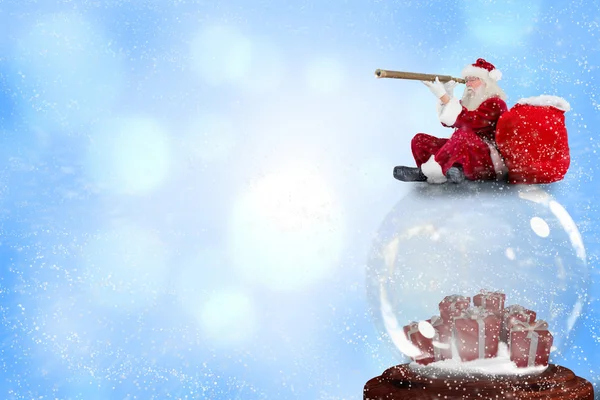Santa sitting on snow globe — Stock Photo, Image