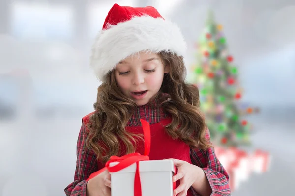 Zusammengesetzte Bild des netten Mädchens, das Geschenk betrachtet — Stockfoto