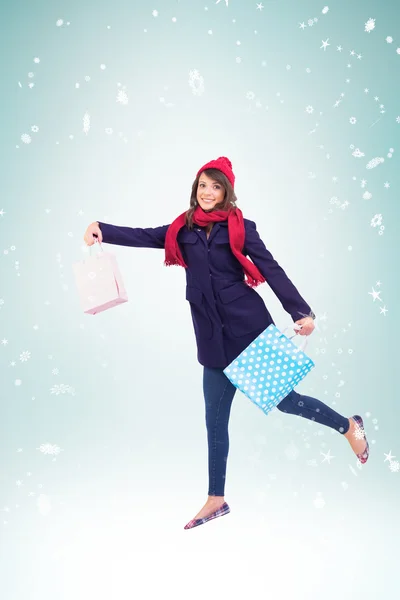 Festive brunette holding shopping bags — Stock Photo, Image