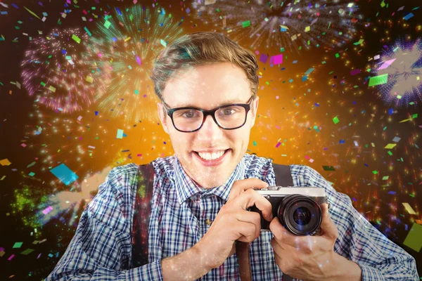 Geeky hipster holding a retro camera — Stock Photo, Image