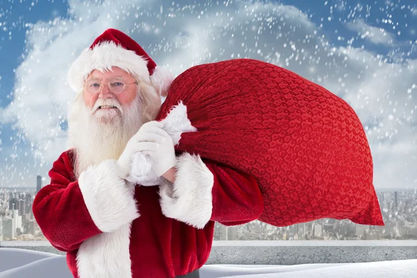 Santa gülümser ve çanta taşır — Stok fotoğraf