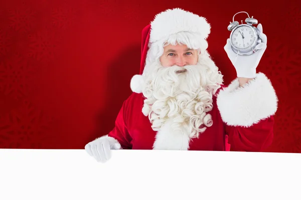 Imagen compuesta de Santa Claus sosteniendo reloj despertador y signo —  Fotos de Stock