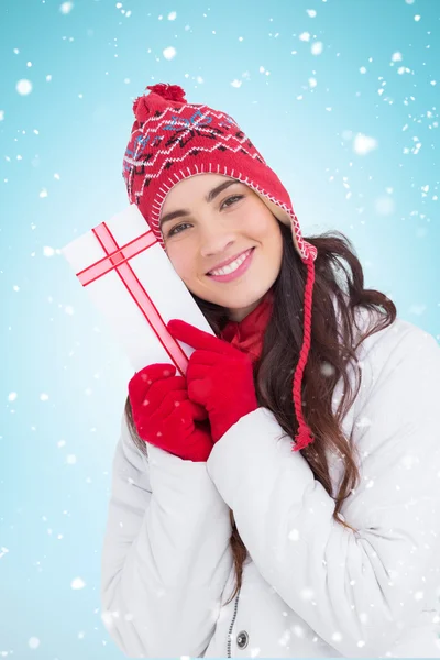 Morena em roupas de inverno mostrando presente — Fotografia de Stock