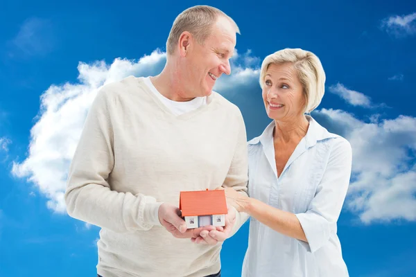 Happy mature couple with model house — Stock Photo, Image