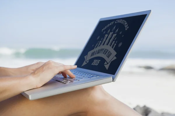 Vrouw op strand met behulp van haar laptop — Stockfoto