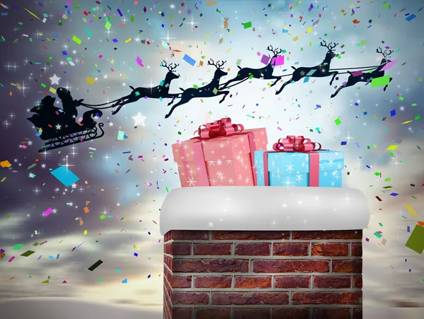 Santa flying behind chimney — Stock Photo, Image