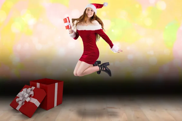 Festive redhead jumping with gift — Stock Photo, Image