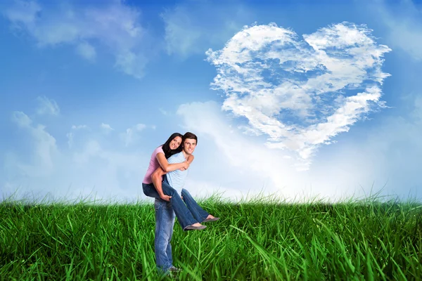 Young man giving girlfriend a piggyback ride — Stock Photo, Image