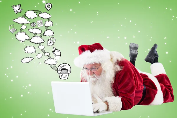 Weihnachtsmann liegt vor seinem Laptop — Stockfoto