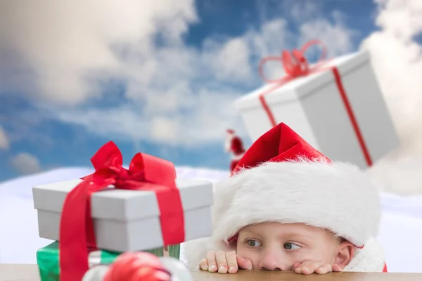 Zusammengesetztes Bild eines niedlichen Jungen, der Geschenke betrachtet — Stockfoto
