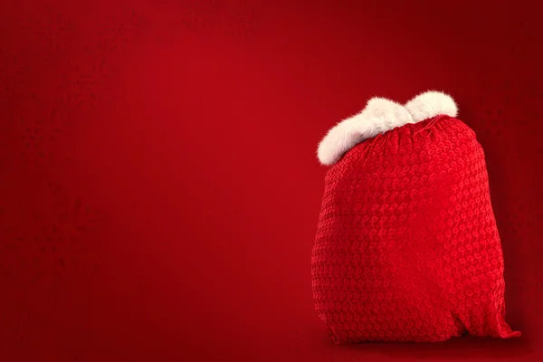 Composite image of santas red bag standing alone — Stock Photo, Image