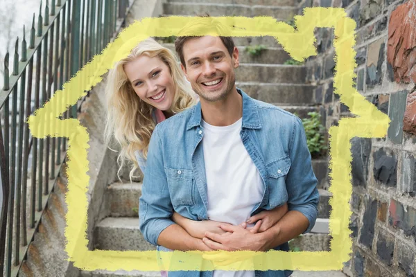 Молодая пара, сидящая на ступеньках, улыбаясь — стоковое фото