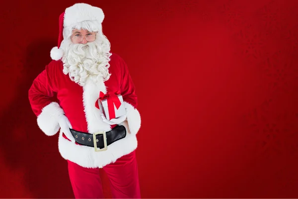 Imagem composta de Papai Noel feliz segurando um presente — Fotografia de Stock