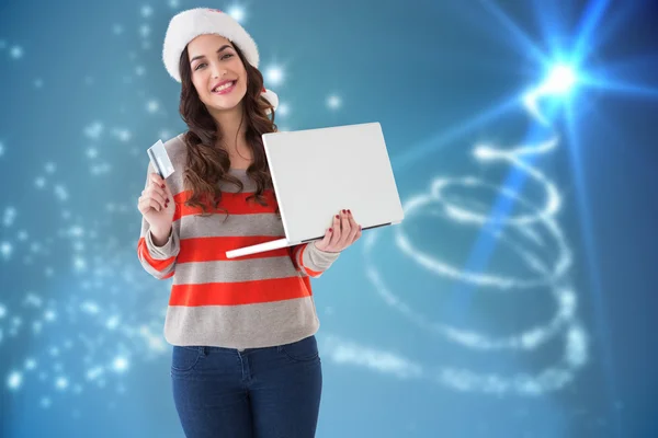 Świąteczny brunetka posiadania laptopa i karty kredytowej — Zdjęcie stockowe