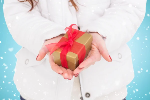 Mujer en abrigo blanco sosteniendo regalo — Foto de Stock