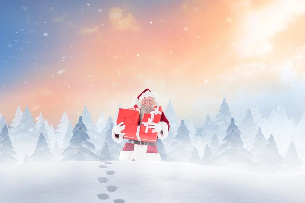 Weihnachtsmann trägt Geschenke im Schnee — Stockfoto