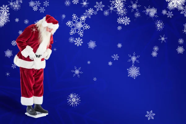 Santa looks down to personal scales — Stock Photo, Image