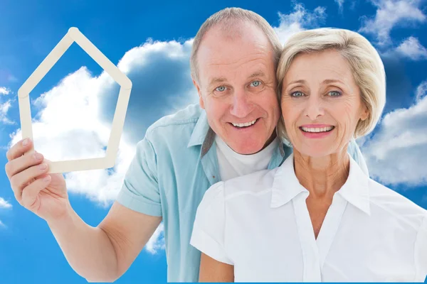 Happy older couple holding house shape — Stock Photo, Image