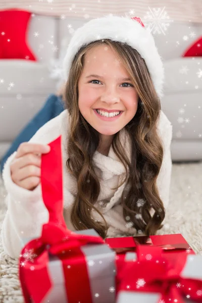 Festive little girl smiling at camera with gifts — Stock Photo, Image