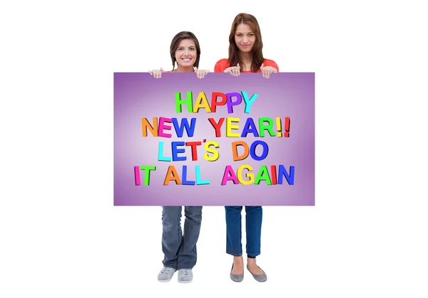 Mujeres jóvenes sonrientes orgullosamente sosteniendo un cartel en blanco — Foto de Stock