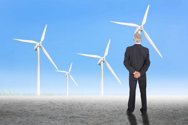Бізнесмен позує проти вітрових турбін — стокове фото