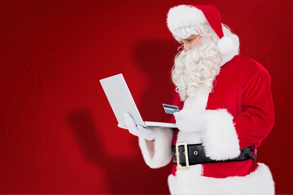Изображение Санта-Клауса в интернет-магазинах с ноутбуком — стоковое фото