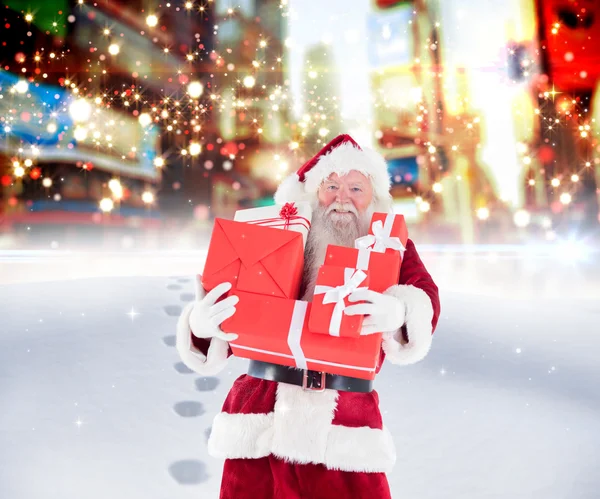 Père Noël portant des cadeaux dans la neige — Photo