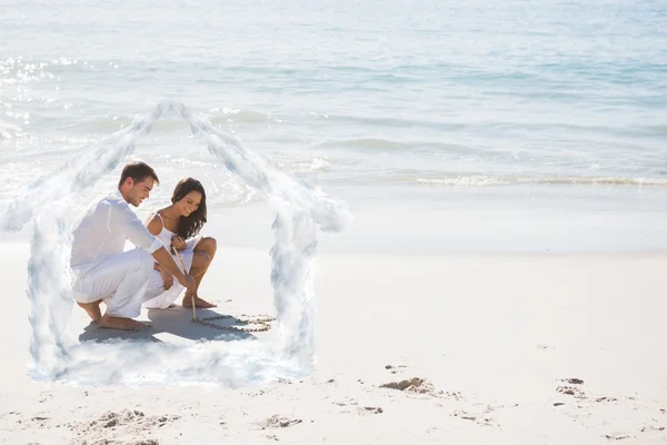 Милая пара рисует сердце в песке — стоковое фото