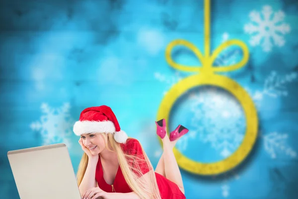 Composite image of festive blonde using a laptop — Stock Photo, Image