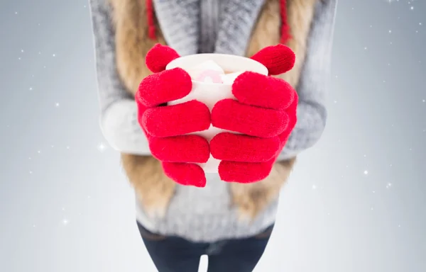 Kvinna i vinterkläder håller mugg — Stockfoto