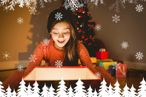 Little girl opening a glowing christmas gift — Stock Photo, Image