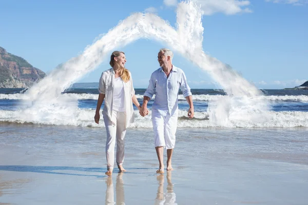 Lyckliga paret gå barfota på stranden — Stockfoto