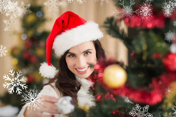 Sorrindo morena segurando uma bugiganga no Natal — Fotografia de Stock