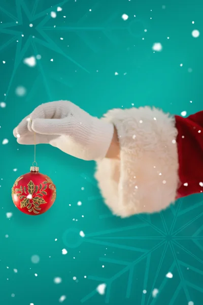 Рука Санты держит рождественскую лампочку — стоковое фото