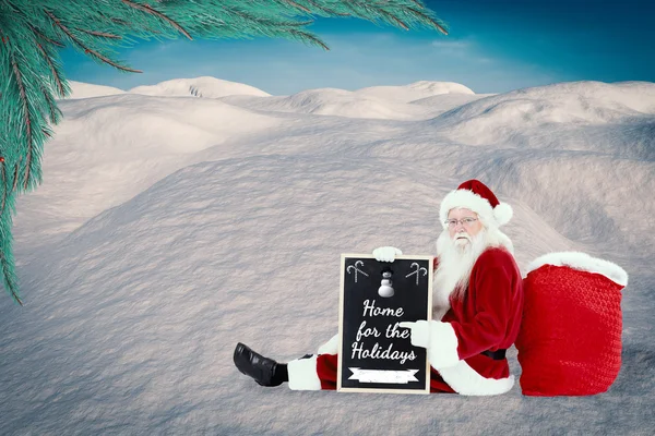 Weihnachtsmann sitzt mit Brett — Stockfoto