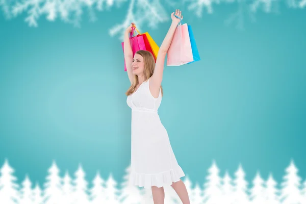 Blonde woman raising shopping bags — Zdjęcie stockowe