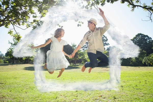 Bonito casal pulando no parque juntos segurar — Fotografia de Stock