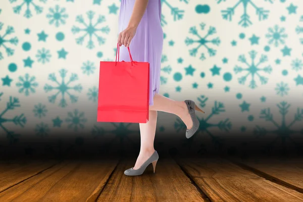 Imagen compuesta de la sección media de la mujer que sostiene la bolsa de compras roja — Foto de Stock