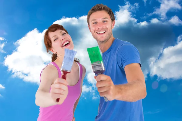 Casal ambos segurando pincéis de pintura — Fotografia de Stock