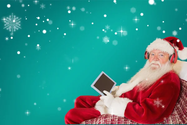 Father christmas listening to music with tablet — Stock Photo, Image