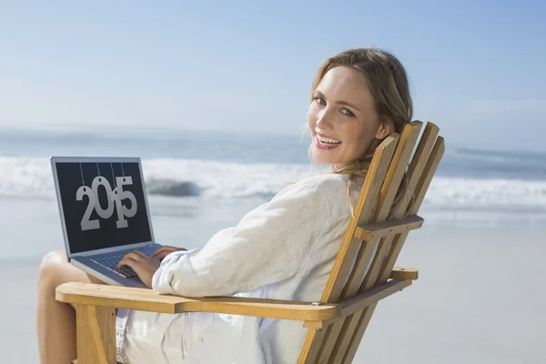 Blonde sitting on deck chair using laptop — Stock Photo, Image