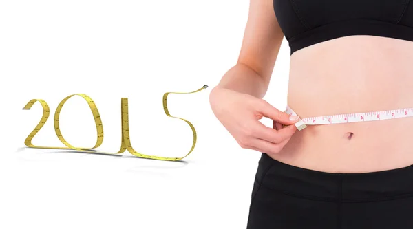 Composite image of fit woman measuring her waist — Stock Photo, Image