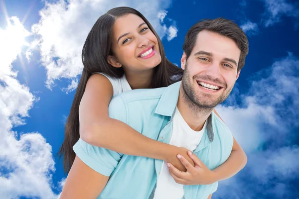 Happy casual man giving pretty girlfriend pig Royalty Free Stock Photos