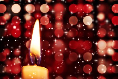 Twinkling stars against candle burning clipart