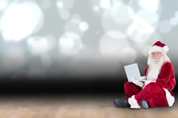 Papai Noel senta e usa um laptop — Fotografia de Stock