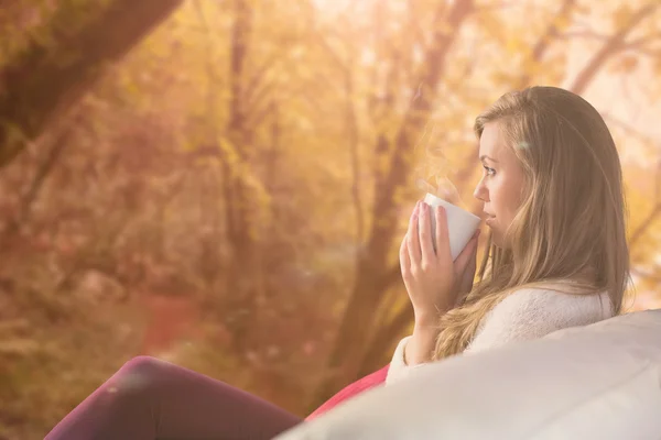 Blonde relaxing on couch with tea — Stock Photo, Image