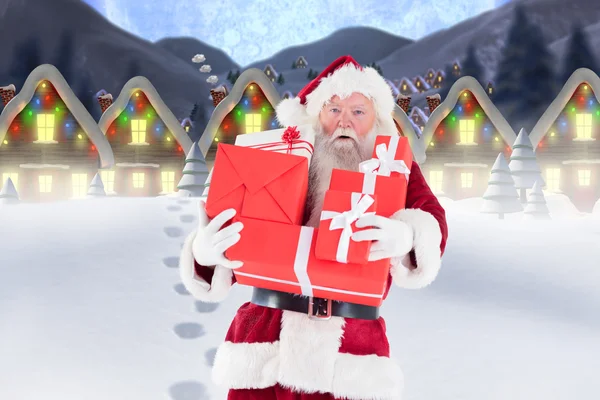 Santa carrying gifts in snow — Stock Photo, Image