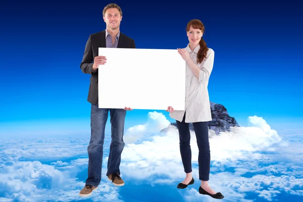 Smiling couple holding large sign — Stockfoto